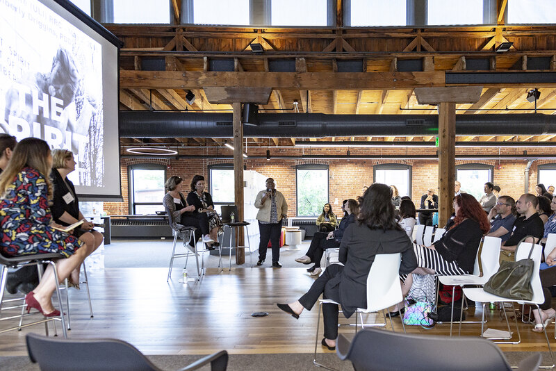 A panel of women presenting to an audience on design for equity and inclusion